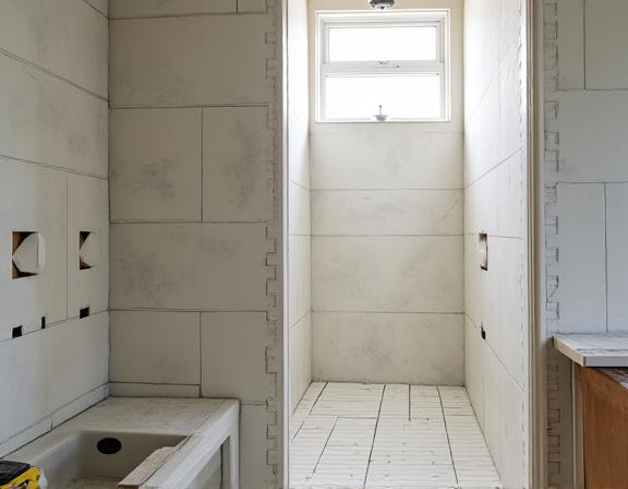 A bathroom renovation in progress with new tiling being installed.